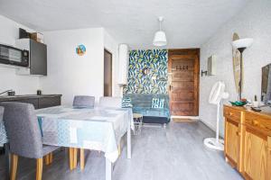 Una cocina y un comedor con mesa y sillas. en Studio refait neuf ,4 personnes, terrasse, parking privé, climatisation, en Le Barcarès