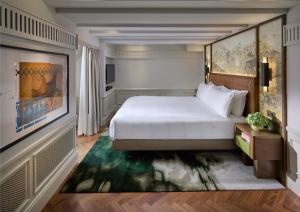 a hotel room with a bed and a painting at Mandarin Oriental Savoy, Zurich in Zurich