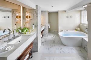 a bathroom with a large tub and a sink at Mandarin Oriental Savoy, Zurich in Zurich