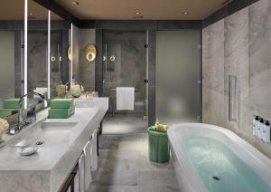a bathroom with two sinks and a bath tub at Mandarin Oriental Savoy, Zurich in Zurich +71 photos