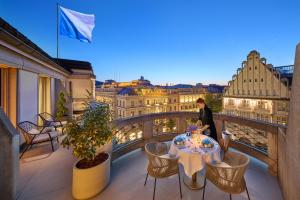 a table on a balcony with a view of the city at Mandarin Oriental Savoy, Zurich in Zurich