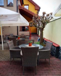 un patio al aire libre con mesas, sillas y un árbol en Ubytování u Smrku, en Jeneč