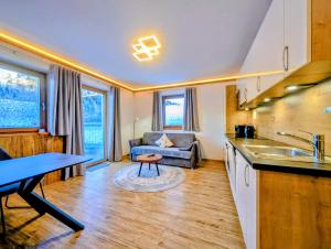 Una cocina y una sala de estar con un sofá y una mesa. en Haus Dirol, en Kirchberg in Tirol