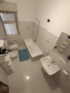 Un baño blanco con lavabo, bañera e inodoro. en Sicily Etna Mareneve Taormina, en Fiumefreddo di Sicilia