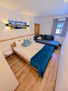 Un dormitorio con una cama grande y un sofá. en Haus Dirol, en Kirchberg in Tirol