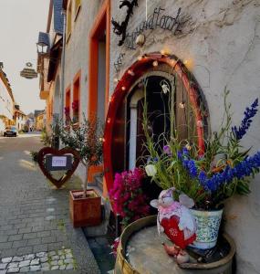 a building with flowers and a teddy bear in front of it at Steinfelderhof in Kröv