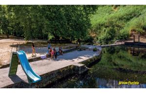 a group of children playing on a slide in a park at Casinha Pôr do Sol in Aldeia das Dez