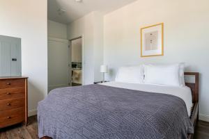 a bedroom with a large bed and a dresser at Blueground Newtonville rooftop nr Newton Centre BOS-1233 in Newton