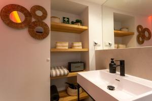 a bathroom with a sink and a mirror at tiny BEACH HOUSES - 2 min to Beach in Salema +26 photos