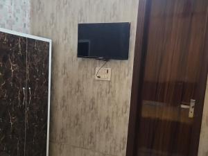 einen Flachbild-TV an der Wand eines Zimmers in der Unterkunft Panipat Town House - Top Rated Property of Panipat in Pānīpat