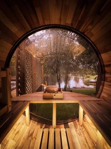 a round window in a wooden cabin with a table at Glencruitten House in Oban