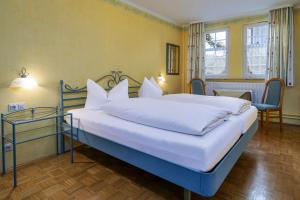 een slaapkamer met een groot bed met witte kussens bij Hotel Bären Meersburg in Meersburg