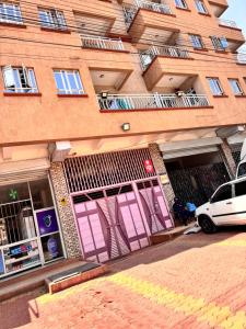 a building with pink doors and a car parked in front at Luxx Homes Properties in Ruiru