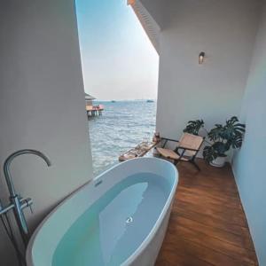 a bathroom with a tub and a view of the ocean at Radda Sea House in Ko Larn +20 photos