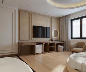 a hotel room with a television and a bed at Lam Anh Hotel 9 Him Lam Vạn Phúc in Hà Ðông