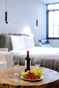 einen Tisch mit einer Tafel Trauben und einer Flasche Wein in der Unterkunft Timeless luxury suites & SPA in Thessaloniki