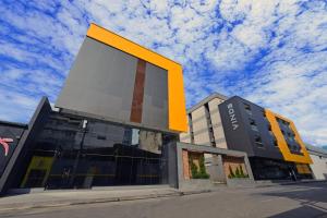a large building with a large yellow rectangle on it at Vinds Economic Hotel in Ipatinga