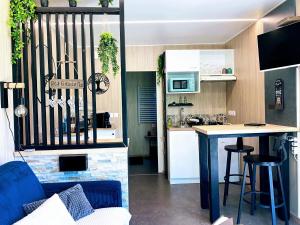 a kitchen and a living room with a table and a counter at le petit gîte de mag in Plouha +17 photos