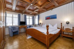 een slaapkamer met een bed, een bureau en een televisie bij Hotel Bären Meersburg in Meersburg