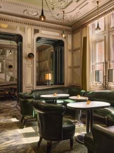a lobby with couches and tables and a mirror at The Connaught, Maybourne in London