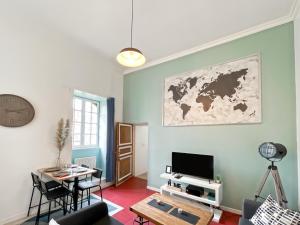 a living room with a tv and a table at Duplex - Place du Parlement de Bretagne - Hyper Centre de Rennes in Rennes +19 photos
