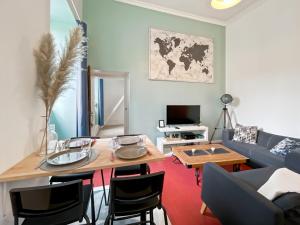 een woonkamer met een tafel en een bank bij Duplex - Place du Parlement de Bretagne - Hyper Centre de Rennes in Rennes