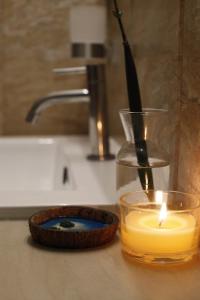 a candle sitting on a counter next to a sink at Samaik Thulusdhoo in Thulusdhoo