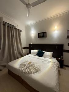 a bedroom with a white bed with areath on it at Samaik Thulusdhoo in Thulusdhoo