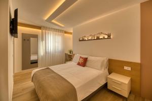 a bedroom with a large bed and a television at La Corte Delle Dolomiti in Agordo