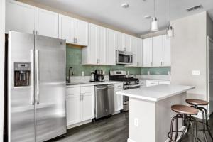 a kitchen with white cabinets and a stainless steel refrigerator at Blueground Bethesda fitness center nr Cabin John Park WDC-571 in Bethesda