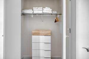 a bathroom with white towels on a shelf at Blueground Bethesda fitness center nr Cabin John Park WDC-571 in Bethesda +29 photos