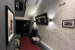 ein Wohnzimmer mit einer Ziegelwand und einem TV in der Unterkunft Pension Falconi in Kolín