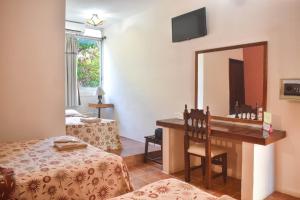 Una habitación de hotel con un escritorio y un espejo. en Hotel Palenque, en Palenque