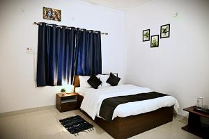 ein Schlafzimmer mit einem Bett und einem Fenster mit blauen Vorhängen in der Unterkunft Krishnayan Homestay in Ranchi