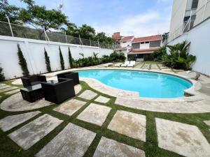 Casa de lujo en Cali con Piscina Privada y BBQ في كالي: مسبح في ساحة فيها كراسي ومبنى