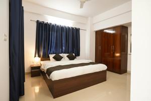 Schlafzimmer mit einem großen Bett und blauen Vorhängen in der Unterkunft Krishnayan Homestay in Ranchi