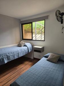 a bedroom with two beds and a window at FlussHaus3 in Villa General Belgrano