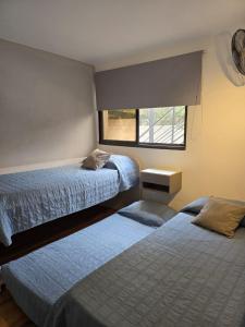 a bedroom with two beds and a window at FlussHaus3 in Villa General Belgrano +37 photos