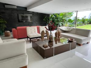Casa de lujo en Cali con Piscina Privada y BBQ في كالي: غرفة معيشة مع أريكة وطاولة قهوة