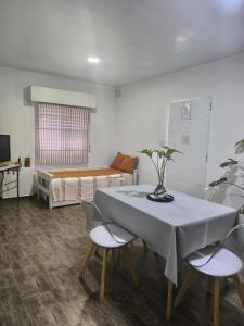 Oasis urbano! Apartamento Geminis complejo في سان نيكولاس دي لوس أرويوس: غرفة مع طاولة وكراسي وسرير