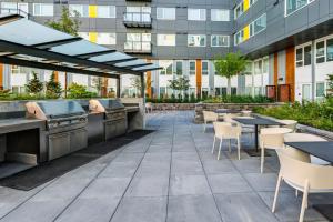 Un patio al aire libre con mesas y sillas y un edificio. en Blueground Overlake fitness center nr Park SEA-897, en Highlands