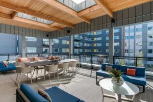 Un patio de apartamentos con mesas, sillas y ventanas. en Blueground Overlake fitness center nr Park SEA-897, en Highlands