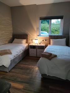 two beds in a room with a window at Direct Travel Stays in Cork