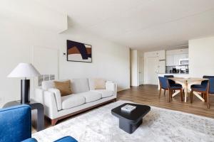 a living room with a couch and a table at Blueground Hudson Exchange pool nr Liberty Park NYC-2174 in Hoboken