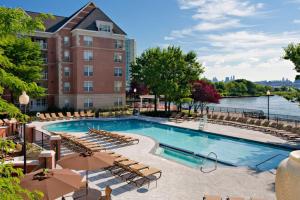 a pool at a hotel with chairs and a building at Blueground Hudson Exchange pool nr Liberty Park NYC-2174 in Hoboken