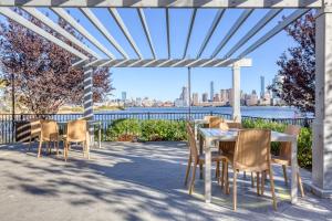 a table and chairs on a patio with a view of the city at Blueground Hudson Exchange pool nr Liberty Park NYC-2174 in Hoboken