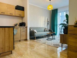 een woonkamer met een bank en een tafel bij Apartament Słoneczny 16 in Opole