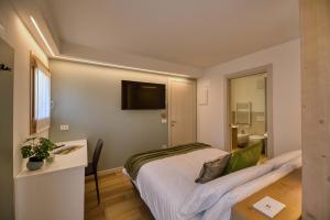 a bedroom with a bed and a tv on the wall at La Corte Delle Dolomiti in Agordo