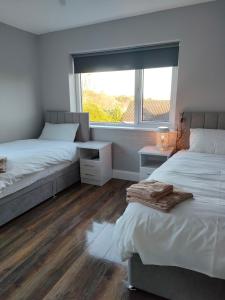 a bedroom with two beds and a window at Direct Travel Stays in Cork