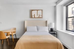 a white bedroom with a bed and a table at Blueground Upper West Side pool nr Central Park NYC-1960 in New York +18 photos